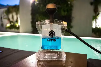 a bottle ofitizer sitting on a table next to a pool at Manousos City Hotel in Rhodes Town