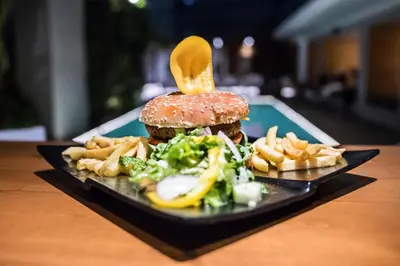 a plate of food with a hamburger and french fries at Manousos City Hotel in Rhodes Town