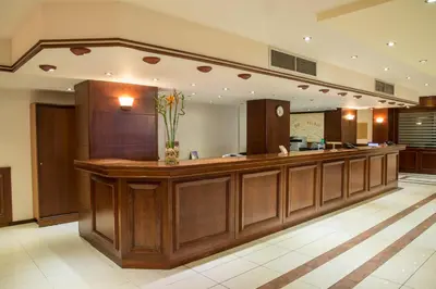 a large lobby with a bar with a vase of flowers at Manousos City Hotel in Rhodes Town