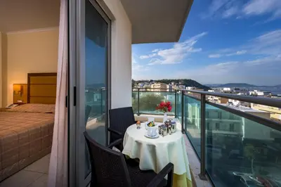 a table on a balcony with a view of the city at Manousos City Hotel in Rhodes Town