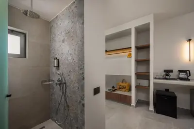 a bathroom with a shower and a walk in closet at Celestial Lindos Suites in Líndos