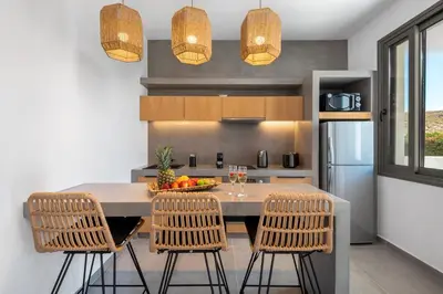 a kitchen with a table with a bowl of fruit on it at Celestial Lindos Suites in Líndos