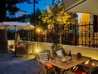 a wooden table with chairs and an umbrella on a patio at Villa Sanyan - Adults Only in Rhodes Town