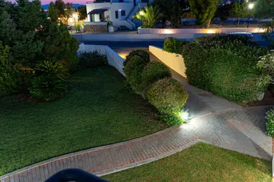 a garden with bushes and a pathway at night at Angela Studios Pefkos in Pefki Rhodes