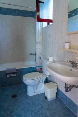 a bathroom with a toilet and a sink and a tub at Angela Studios Pefkos in Pefki Rhodes