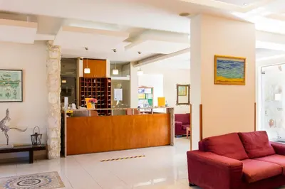 a living room with a red couch and a counter at Ilyssion Holidays Hotel in Ialyssos