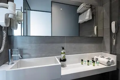 a bathroom with a white sink and a mirror at Oktober Downtown Boutique Hotel in Rhodes Town