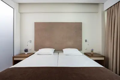 a bedroom with a large white bed with two tables at Oktober Downtown Boutique Hotel in Rhodes Town