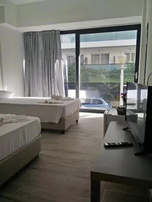 a hotel room with two beds and a large window at New York Hotel in Rhodes Town