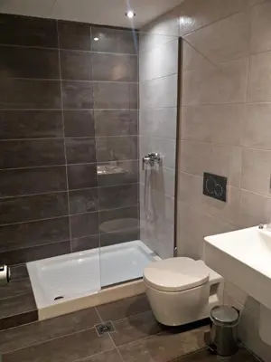 a bathroom with a shower and a toilet and a sink at New York Hotel in Rhodes Town