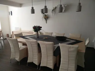 a dining room table with white chairs and a table with flowers at New York Hotel in Rhodes Town