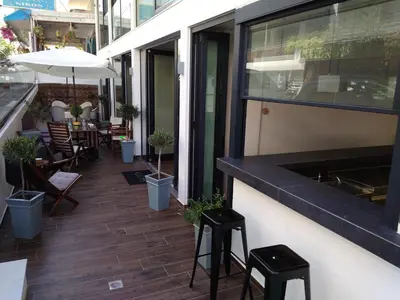 an outdoor patio with stools and tables and chairs at New York Hotel in Rhodes Town