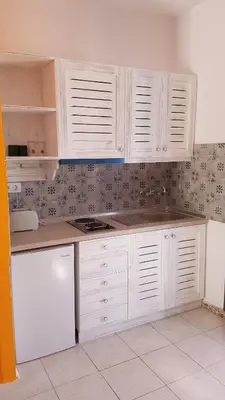 a kitchen with white cabinets and a white refrigerator at Andreas Studios in Pefki Rhodes