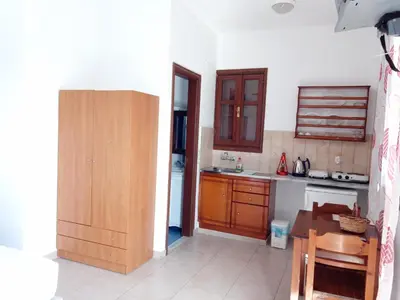 a kitchen with wooden cabinets and a table in it at Andreas Studios in Pefki Rhodes