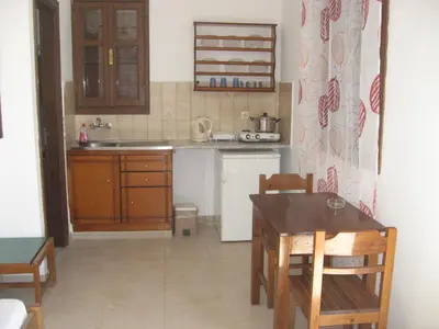 a kitchen with a table and a sink and a table and chairs at Andreas Studios in Pefki Rhodes