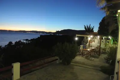 a restaurant with a view of the ocean at night at Andreas Studios in Pefki Rhodes