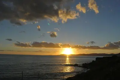 a sunset over the ocean with the sun setting at Andreas Studios in Pefki Rhodes