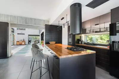 a kitchen with black cabinets and a counter with stools at Villa Eleven in Ialyssos