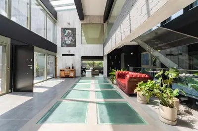 a hallway of a building with green floors and plants at Villa Eleven in Ialyssos