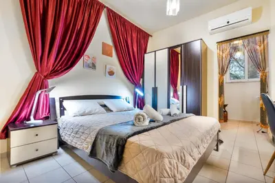 a bedroom with a large bed with red curtains at COLONIAL FAMILY apartment #4 ground floor in Faliraki