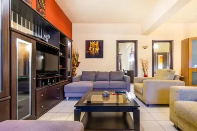 a living room with a couch and a tv at COLONIAL FAMILY apartment #4 ground floor in Faliraki