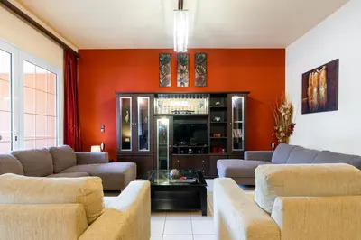 a living room with orange walls and couches at COLONIAL FAMILY apartment #4 ground floor in Faliraki