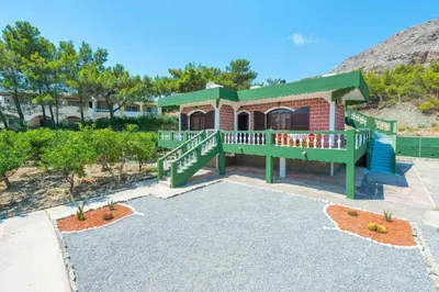 a small house with a green roof and a porch at Villa Agia Galini in Archangelos