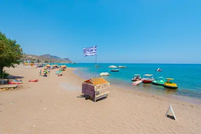 a group of people on a beach with boats in the water at Villa Agia Galini in Archangelos