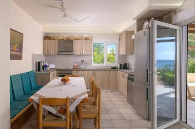 a kitchen and dining room with a table and chairs at Edem Paradise in Plimmiri