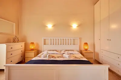 a bedroom with a white bed and two lamps at Edem Paradise in Plimmiri