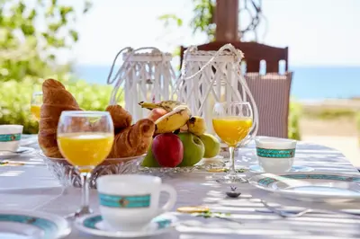 a table with a basket of food and glasses of orange juice at Edem Paradise in Plimmiri