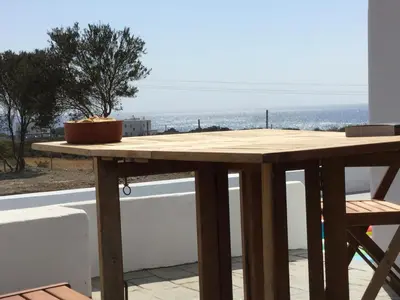 a table on a balcony with a view of the ocean at Sea Breeze Villas in Lachania