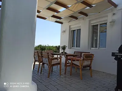 a patio with a wooden table and chairs at Sea Breeze Villas in Lachania
