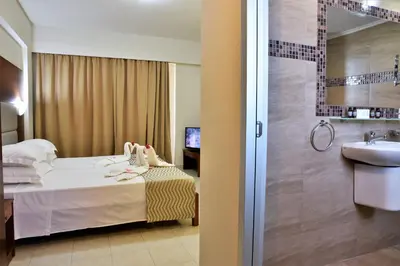 a bathroom with a bed and a sink and a shower at Marathon Hotel - All Inclusive in Kolimbia