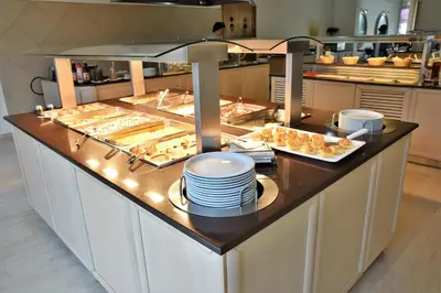 a buffet line with plates and pastries in a kitchen at Marathon Hotel - All Inclusive in Kolimbia