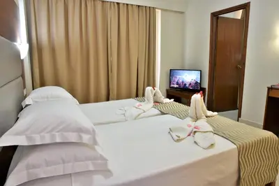 two beds in a hotel room with towels on them at Marathon Hotel - All Inclusive in Kolimbia