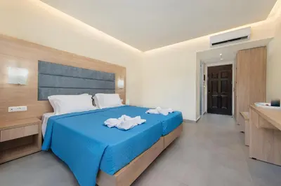 a bedroom with a blue bed and a sink at Marathon Hotel - All Inclusive in Kolimbia