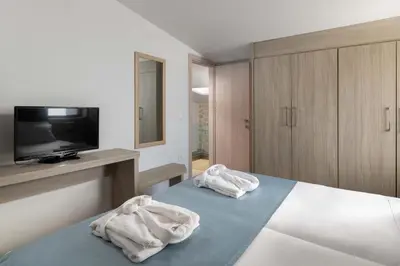 a bedroom with a bed with white towels on it at Sperveri Enalio Villas - Heated Pool in Kolimbia