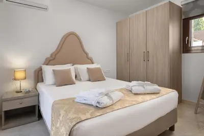 a bedroom with a large white bed with towels on it at Sperveri Enalio Villas - Heated Pool in Kolimbia