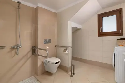a bathroom with a toilet and a window in it at Sperveri Enalio Villas - Heated Pool in Kolimbia