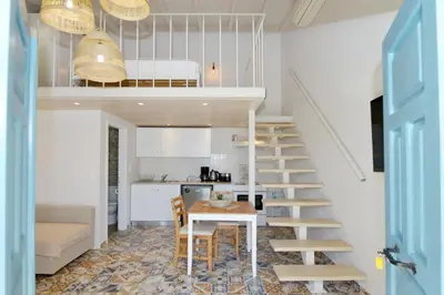 a kitchen and dining room with a staircase and a table at Spitakia in Halki