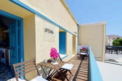 a balcony with a table and chairs on a building at Spitakia in Halki