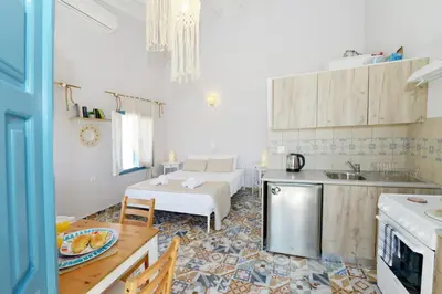 a kitchen and living room with a table and a couch at Spitakia in Halki