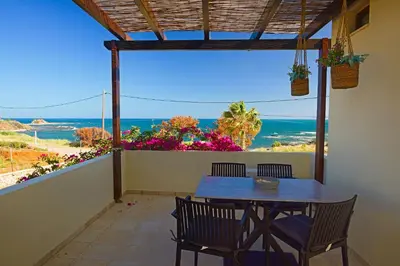a table and chairs on a balcony with a view of the ocean at Villa Sunrise by the Sea in Kiotari