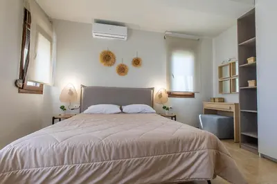 a bedroom with a large bed with two lamps on the wall at Villa Sunrise by the Sea in Kiotari