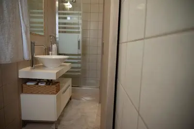 a bathroom with a white sink and a mirror at Villa Sunrise by the Sea in Kiotari