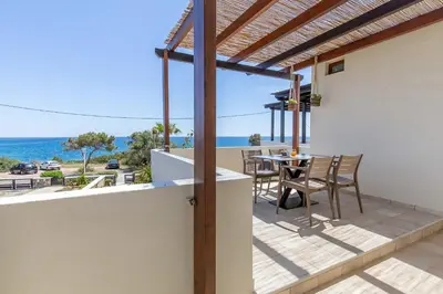 a balcony of a house with a table and chairs at Villa Sunrise by the Sea in Kiotari