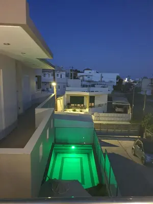 a green swimming pool on the side of a building at Kiriakos Apartment in Afantou