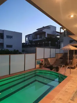 a swimming pool on the roof of a building at Kiriakos Apartment in Afantou