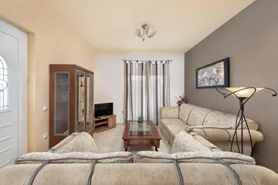 a living room with two couches and a tv at Kiriakos Apartment in Afantou